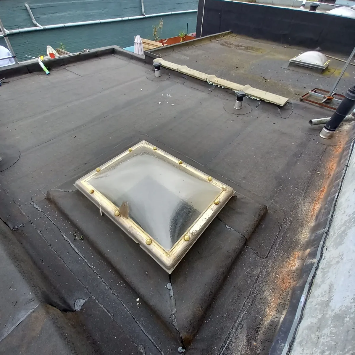 Bitumineuze dakbedekking op een plat dak met Dakkoepel en ventilatiepijpen