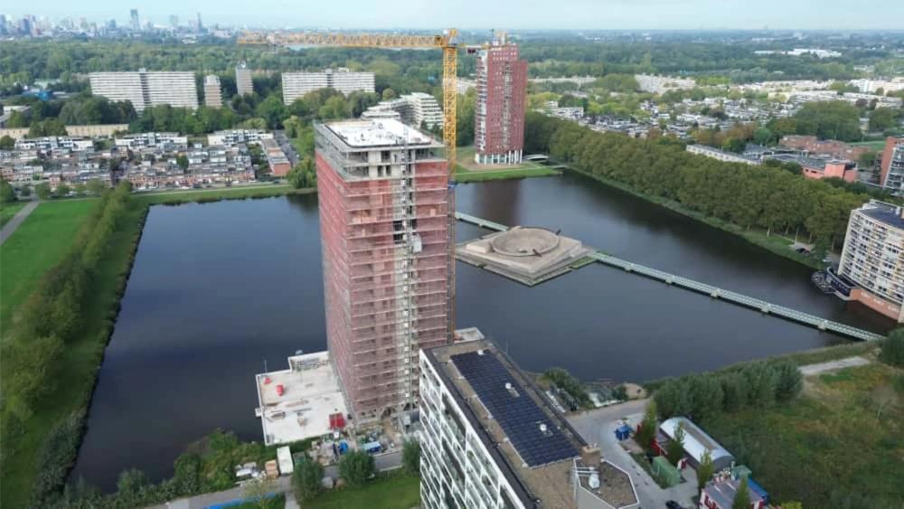 Torenkraan bij hoog flatgebouw met steiger aan het dak voor Kraan