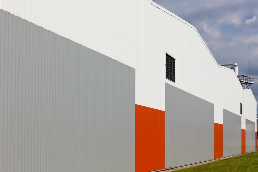 Industriële gevel met grijze en oranje trapeziumplaat