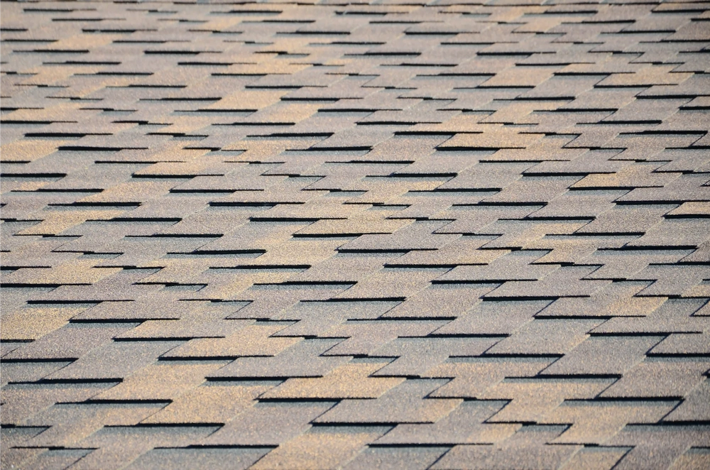Close-up van grijze bitumen dakshingles in regelmatig rustiek patroon