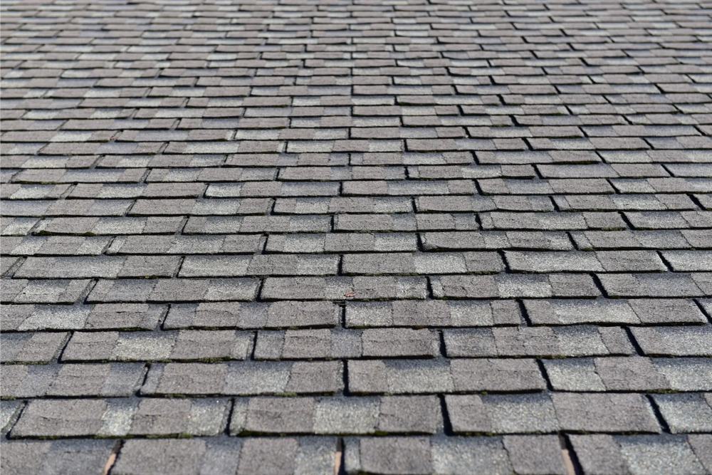 Dak bedekt met grijze bitumen shingles in regelmatige rijen