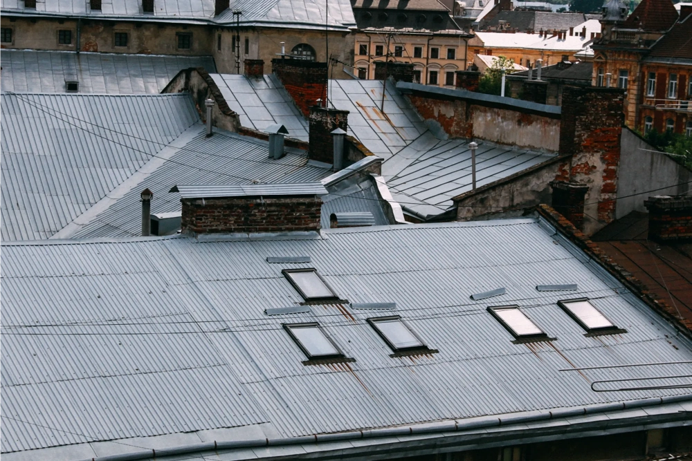 Corrugated metalen dak van trapeziumplaat met dakramen en schoorsteen